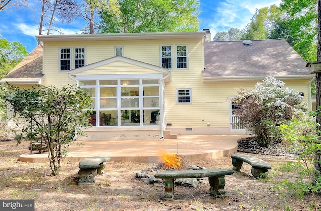 back of house featuring crawl space, a chimney, roof with shingles, a sunroom, and a patio