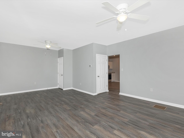 empty room with baseboards, a ceiling fan, dark wood-style flooring, and visible vents