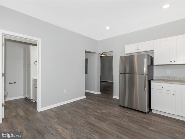 kitchen with white cabinetry, light countertops, dark wood-style floors, and freestanding refrigerator