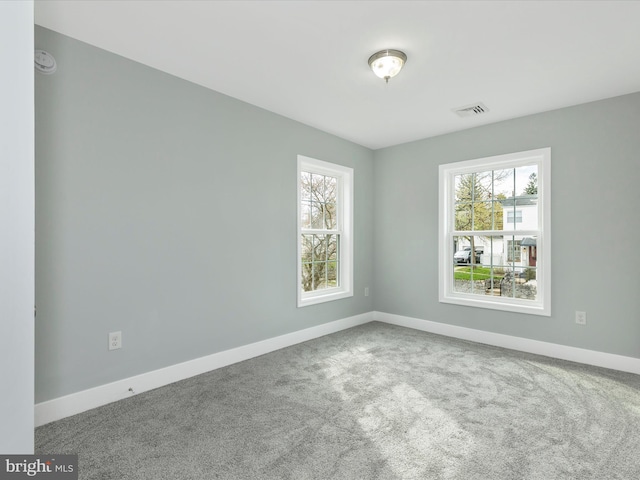 spare room with visible vents, baseboards, and carpet