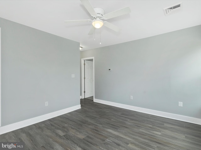 empty room with a ceiling fan, baseboards, dark wood-style flooring, and visible vents