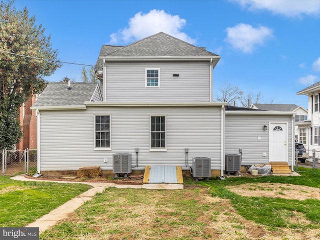 back of house with a yard, fence, roof with shingles, and cooling unit