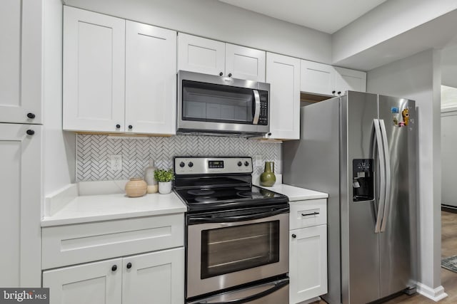 1070 Trevino Ln, Herndon, VA 20170 - kitchen featuring wood finished floors, backsplash, white cabinets, and stainless steel appliances