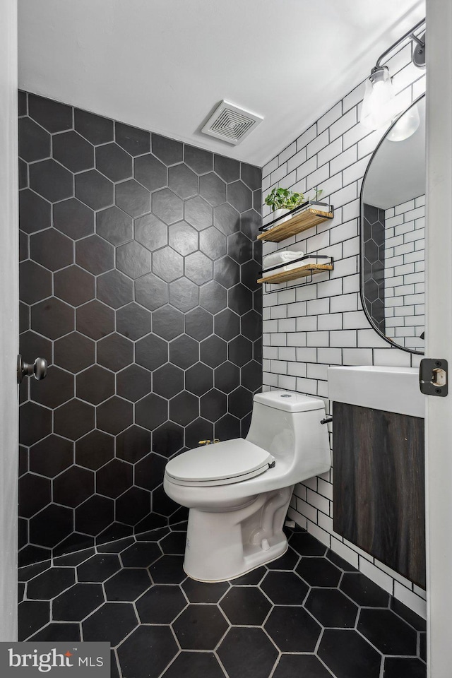 1070 Trevino Ln, Herndon, VA 20170 - full bath with vanity, toilet, tile walls, visible vents, and tiled shower