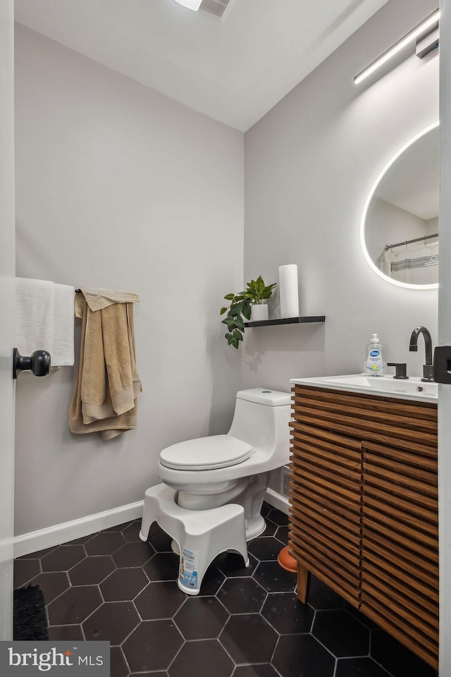 1070 Trevino Ln, Herndon, VA 20170 - full bath featuring toilet, baseboards, tile patterned flooring, and vanity