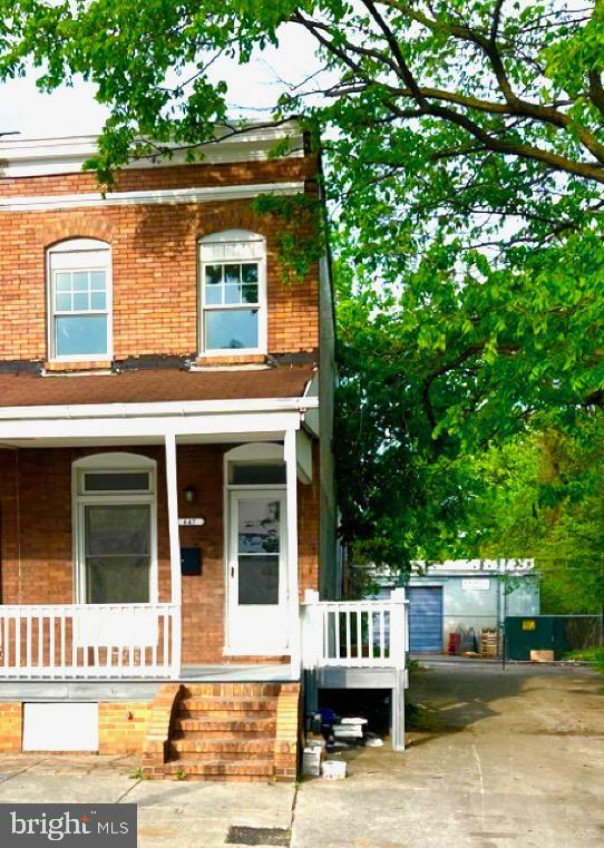 view of front of house featuring covered porch and brick siding