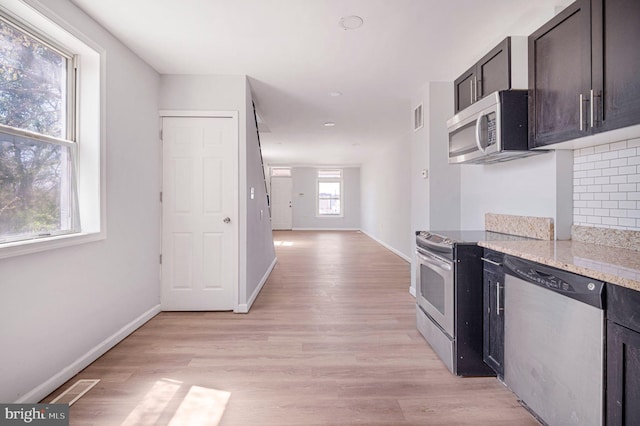 647 S Pulaski St, Baltimore, MD 21223 - kitchen featuring visible vents, light wood-style flooring, baseboards, and appliances with stainless steel finishes