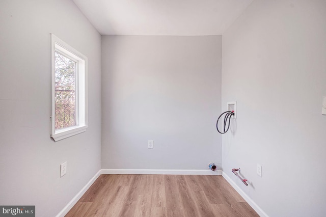 clothes washing area featuring laundry area, light wood-style floors, hookup for a washing machine, hookup for a gas dryer, and baseboards