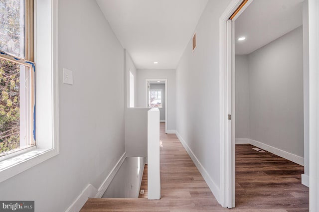 647 S Pulaski St, Baltimore, MD 21223 - hall featuring baseboards, wood finished floors, visible vents, and an upstairs landing