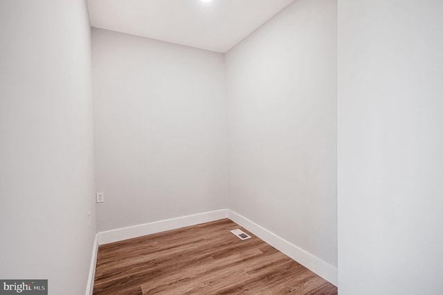 empty room with baseboards, wood finished floors, and visible vents