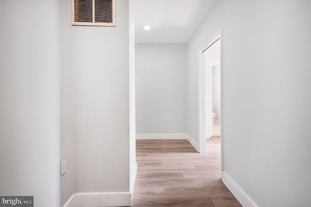 hallway featuring baseboards, recessed lighting, wood finished floors, and visible vents