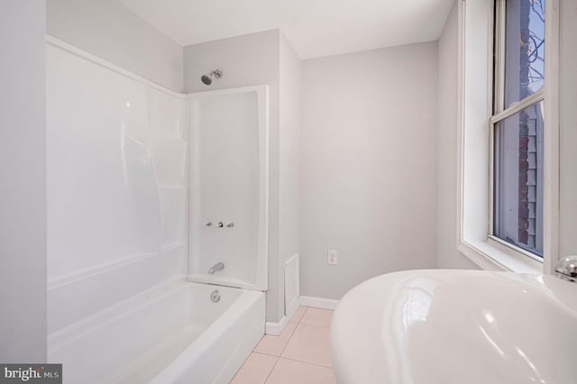 full bathroom featuring washtub / shower combination, tile patterned flooring, and baseboards