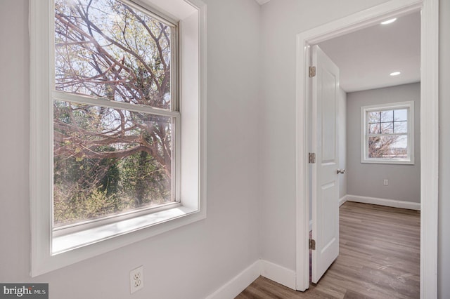 hallway with baseboards and wood finished floors