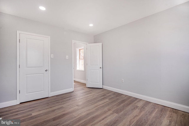 unfurnished bedroom featuring baseboards, recessed lighting, and wood finished floors