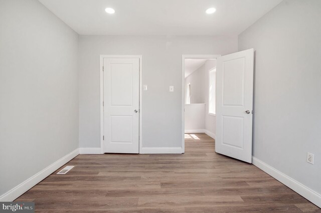 647 S Pulaski St, Baltimore, MD 21223 - unfurnished bedroom with baseboards, recessed lighting, wood finished floors, and visible vents