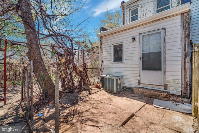 exterior space featuring fence, central AC unit, and a patio area