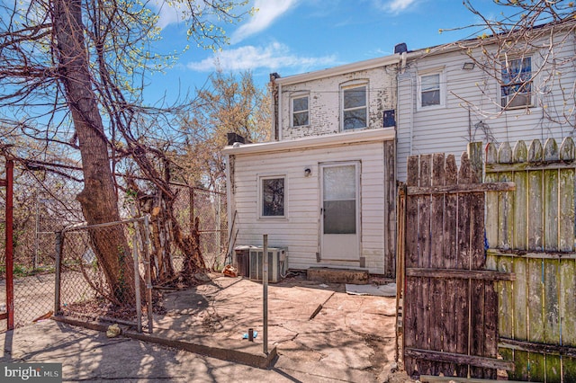 back of property featuring fence, a gate, and central AC unit