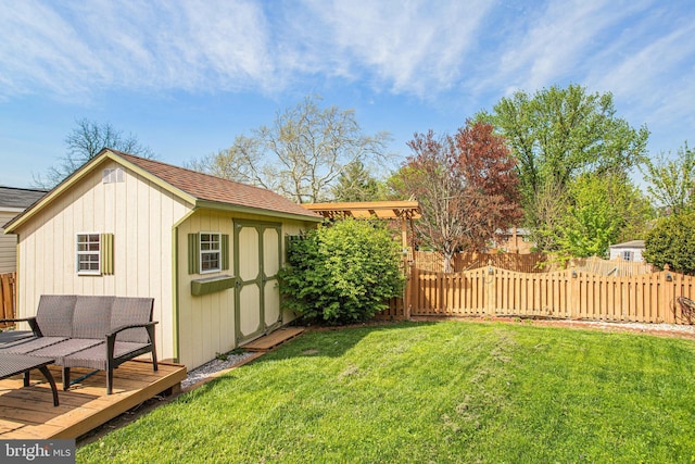 view of yard featuring an outdoor structure, a deck, a storage unit, and fence