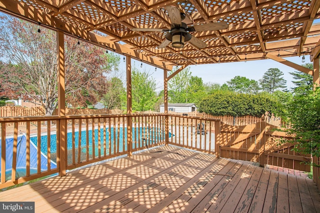 deck featuring ceiling fan, a fenced backyard, a pergola, and an outdoor pool