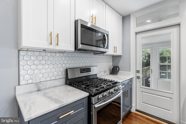 kitchen with stainless steel appliances, white cabinetry, light countertops, and tasteful backsplash
