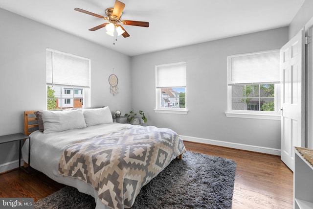 bedroom featuring wood finished floors, baseboards, and ceiling fan