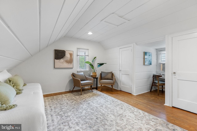 bedroom with wood finished floors, multiple windows, vaulted ceiling, and baseboards