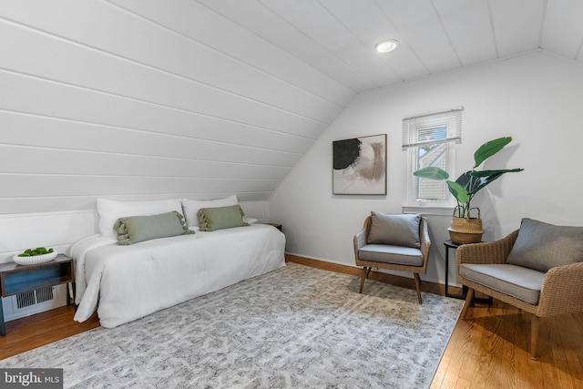 bedroom with vaulted ceiling and wood finished floors