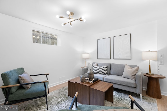 living area with a chandelier, wood finished floors, and baseboards