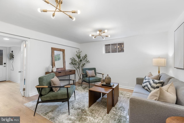 living room with a chandelier, light wood-style flooring, and baseboards