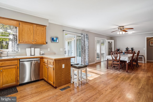 813 Petinot Pl, Stevensville, MD 21666 - kitchen featuring stainless steel dishwasher, a peninsula, a kitchen breakfast bar, light countertops, and ornamental molding