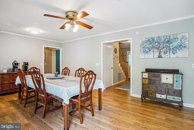 813 Petinot Pl, Stevensville, MD 21666 - dining area with a ceiling fan, crown molding, stairs, light wood-style floors, and baseboards