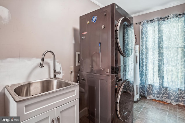 813 Petinot Pl, Stevensville, MD 21666 - laundry room with stacked washer / drying machine, cabinet space, and crown molding