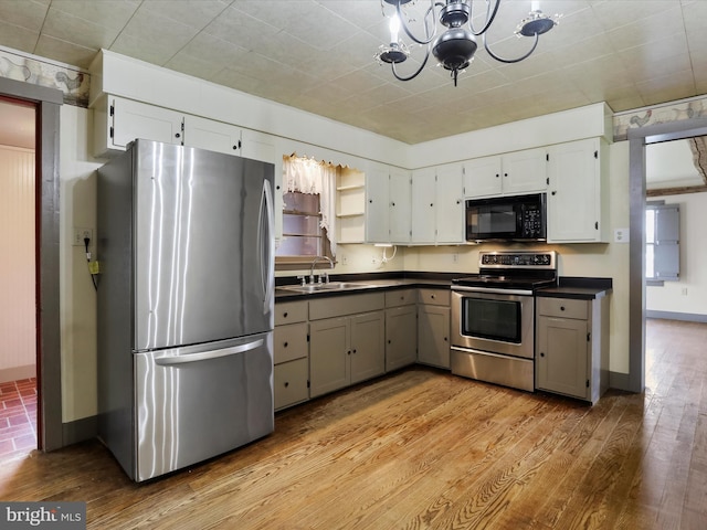 2297 Big Cove Tannery Rd, Big Cove Tannery, PA 17212 - kitchen with dark countertops, a sink, a chandelier, light wood-style flooring, and appliances with stainless steel finishes