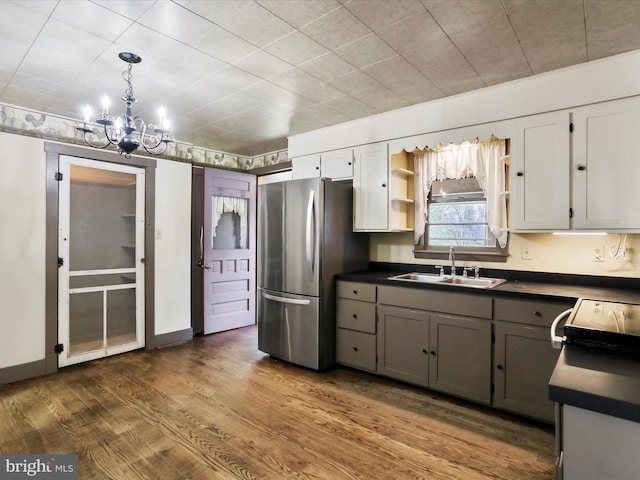 2297 Big Cove Tannery Rd, Big Cove Tannery, PA 17212 - kitchen with a sink, dark countertops, freestanding refrigerator, an inviting chandelier, and wood finished floors