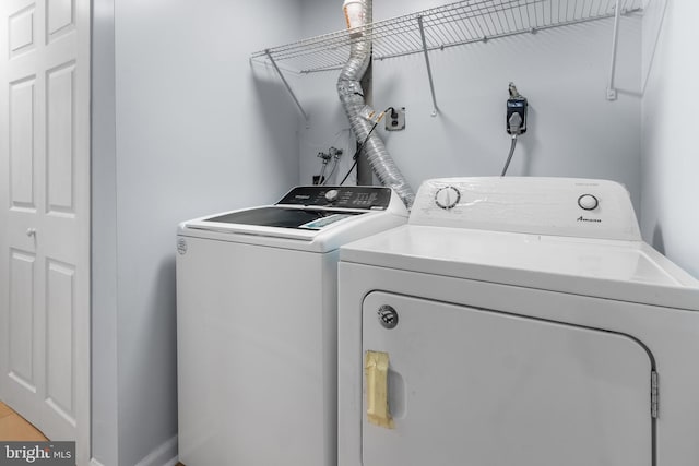laundry room with washing machine and clothes dryer and baseboards