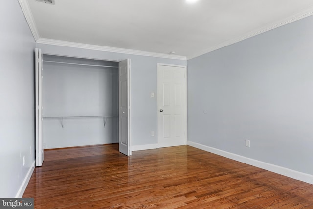 unfurnished bedroom featuring crown molding, wood finished floors, and a closet