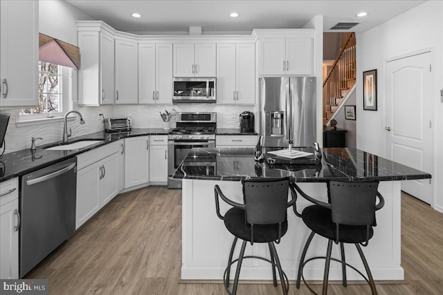 kitchen with visible vents, stainless steel appliances, white cabinets, and a sink