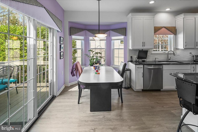 kitchen featuring recessed lighting, a sink, light wood-style floors, backsplash, and stainless steel dishwasher