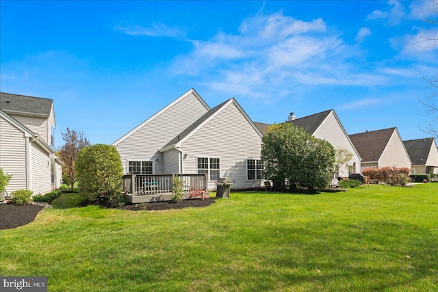 back of house featuring a wooden deck and a lawn