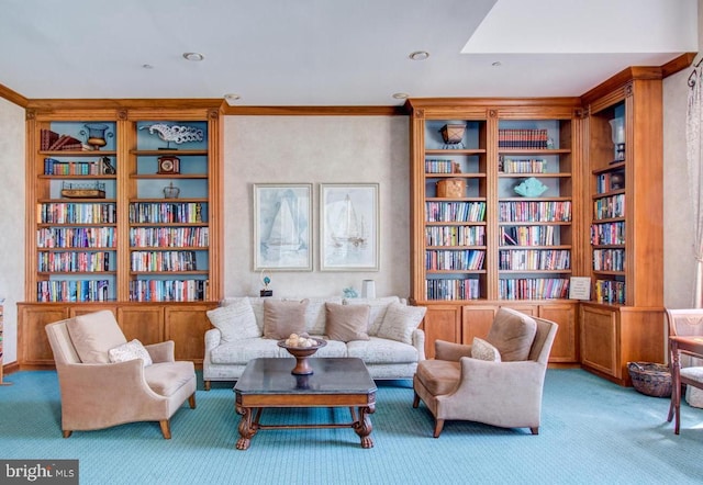 sitting room with ornamental molding, bookshelves, built in features, and carpet