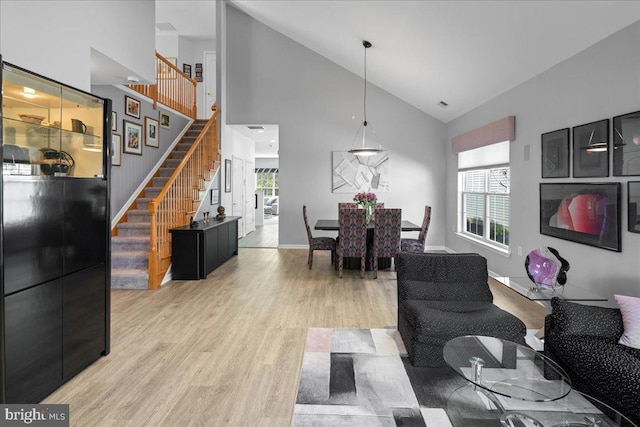 living room with light wood finished floors, stairway, and a wealth of natural light