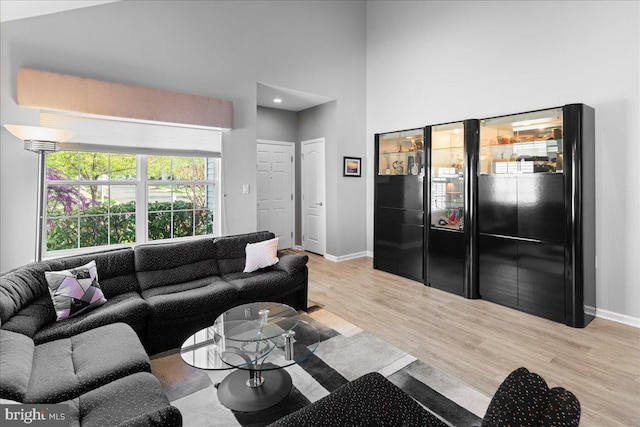 living room with baseboards, recessed lighting, and light wood finished floors
