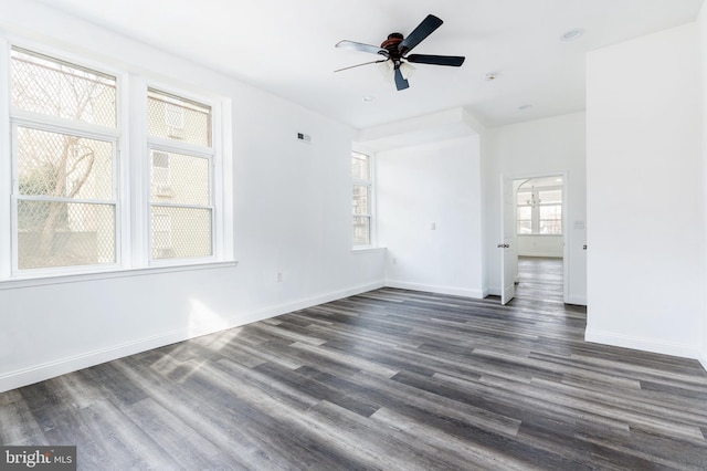 interior space with baseboards, a ceiling fan, and dark wood-style floors