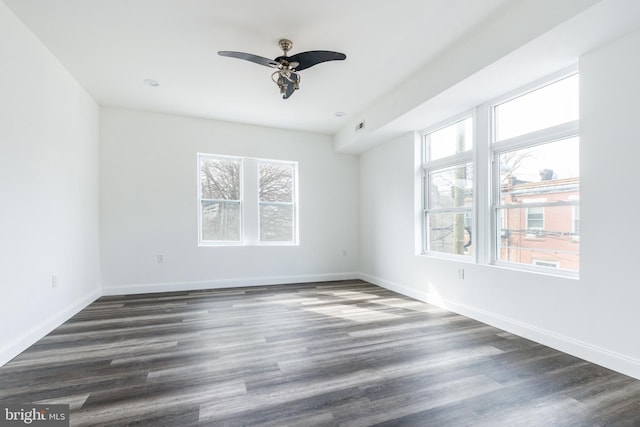 empty room with visible vents, baseboards, ceiling fan, and dark wood-style flooring