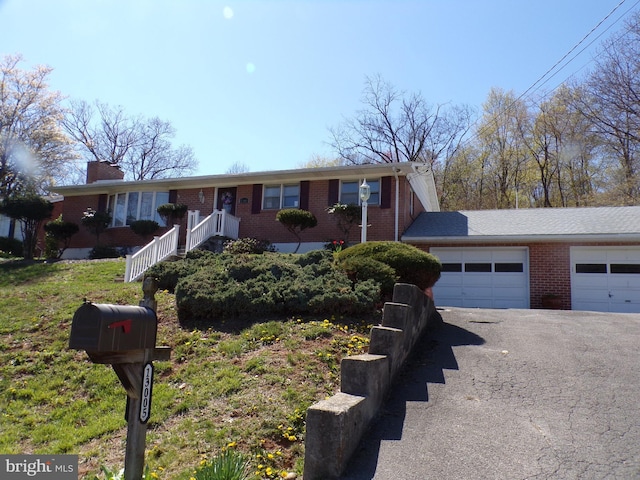 single story home with brick siding, aphalt driveway, and a garage