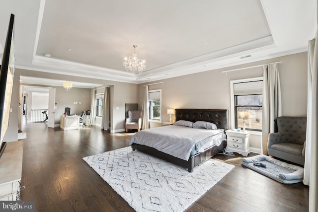 bedroom with an inviting chandelier, ornamental molding, a tray ceiling, and dark wood-style floors