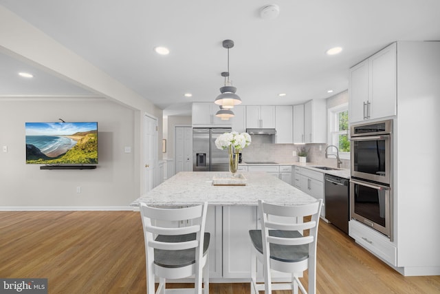 1004 Union Church Rd, Mclean, VA 22102 - kitchen with light stone counters, a sink, appliances with stainless steel finishes, a center island, and backsplash