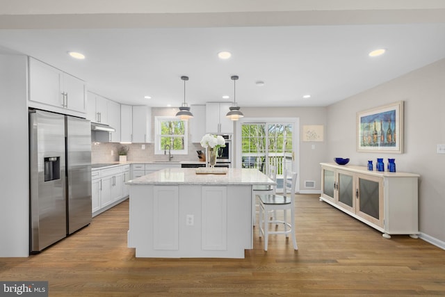 1004 Union Church Rd, Mclean, VA 22102 - kitchen with white cabinets, a sink, under cabinet range hood, a center island, and stainless steel refrigerator with ice dispenser