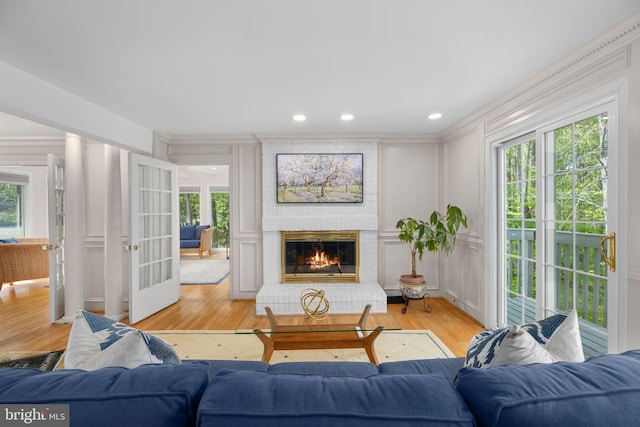 1004 Union Church Rd, Mclean, VA 22102 - living room featuring a brick fireplace, light wood-style flooring, a decorative wall, ornamental molding, and french doors