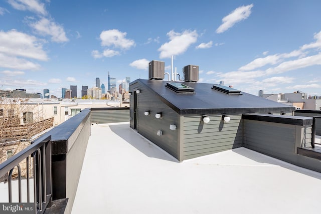 view of side of property featuring a skyline view, a balcony, and central AC unit